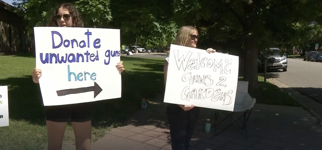 gun violence reduction | gun donation event denver | image of people holding signs at a gun donation event
