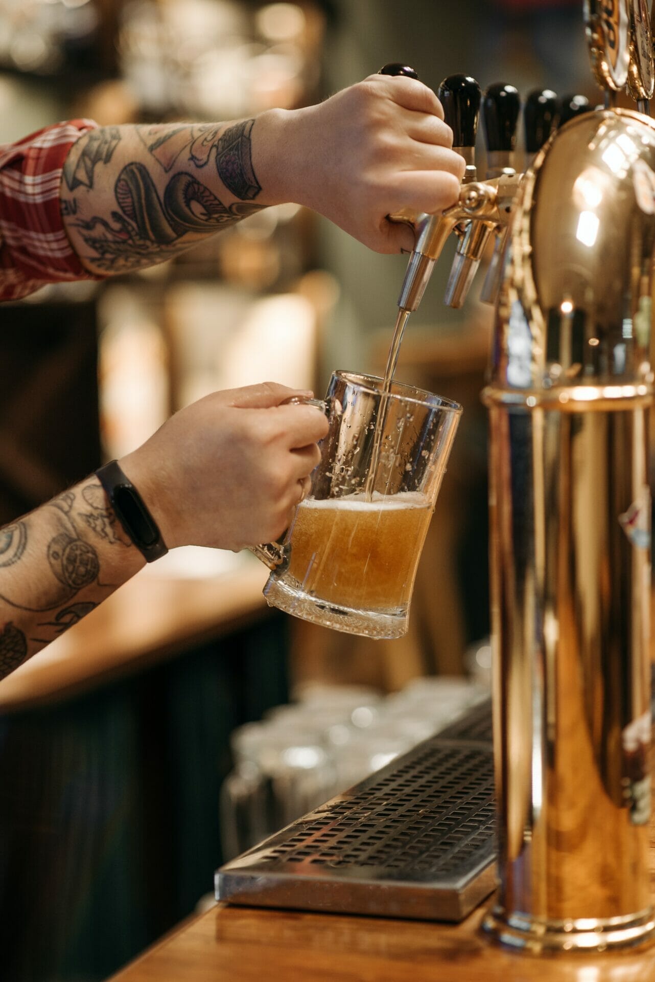image of a tattooed arm pouring a beer